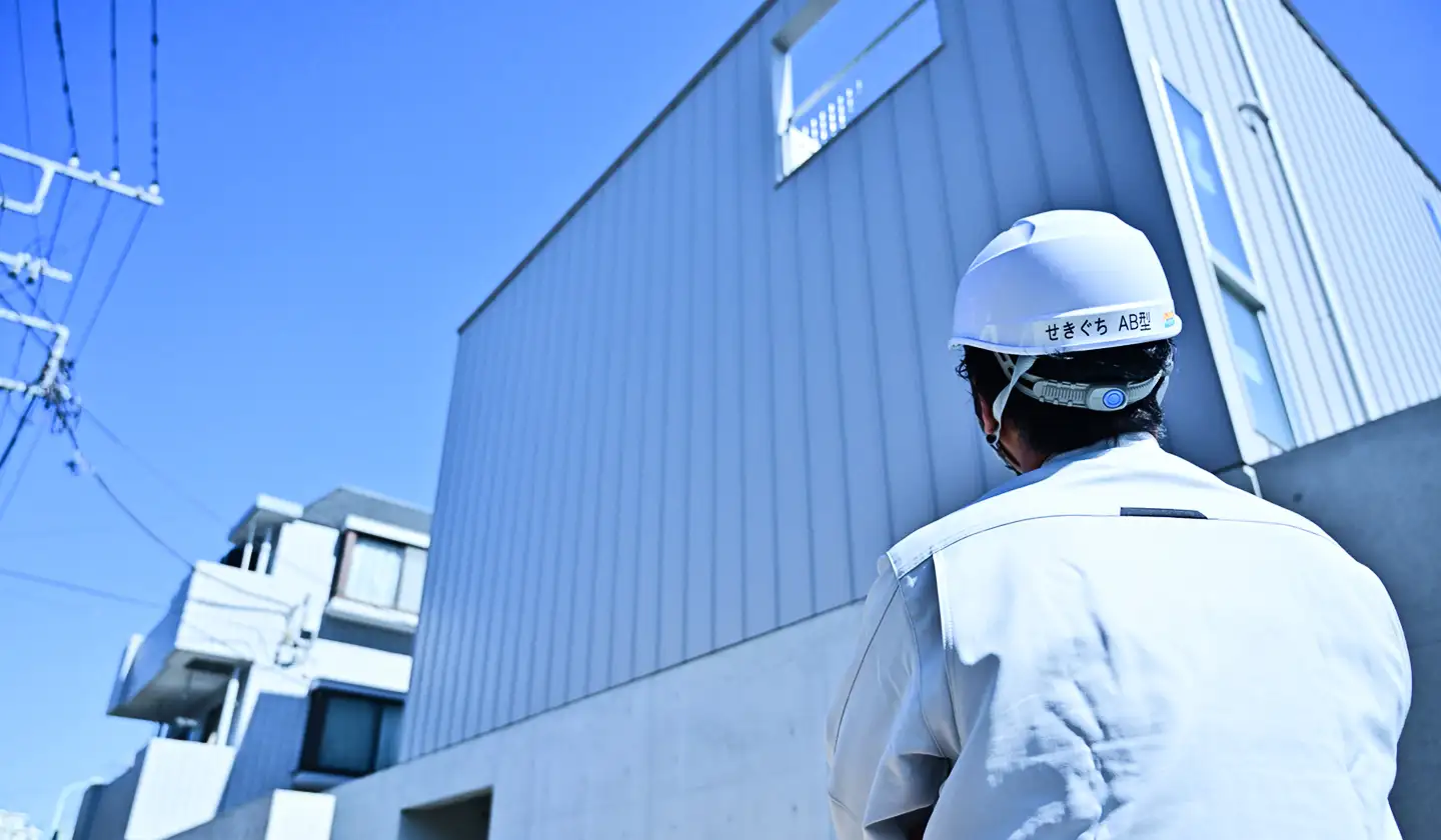 建設現場で建物を見上げる作業員
