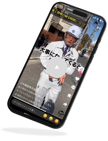 街中で動画配信中。白い作業服にヘルメット、真剣な表情の監督。