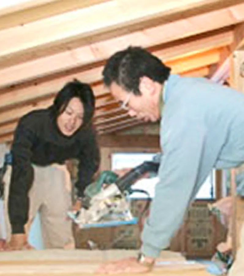 家を建てる職人たち、木材を丁寧に切る姿